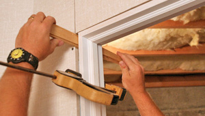 Installing trim and finishing touches to a remodeled basement in Haubstadt, IN and KY