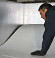 contractor installing TerraBlock™ floor insulation in a Washington crawl space