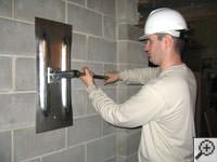 Attempting to straighten a bowed foundation wall by straightening a wall anchor system in a Washington home.