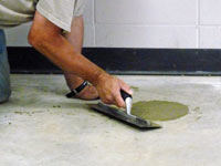 Repairing the cored holes in the concrete slab floor with fresh concrete and cleaning up the Washington home.