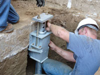 Foundation repair contractors installing the foundation bracket in Newburgh.