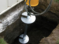 Installing a helical pier system in the earth around a foundation in Henderson