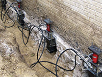 Using foundation push piers to lift a foundation during a repair in Sheperdsville.