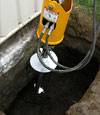 Installing a helical pier during a foundation repair in Henderson