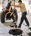 Digging a hole in the garage floor to make room for a wall anchor installation in Utica, Indiana and Kentucky