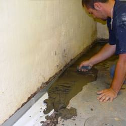 A basement waterproofer installing a perimeter drain system in Marion