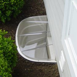 A vinyl basement window and covered window well in Hartford