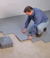 Contractors installing basement subfloor tiles and matting on a concrete basement floor in Madisonville, Indiana and Kentucky