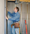 Insulated basement wall panels being placed against a concrete foundation wall in Haubstadt